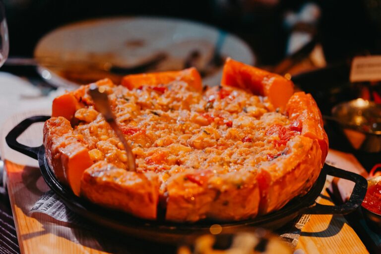 Close-up of a cheesy deep dish pizza with vegetables, perfect for a hearty meal.