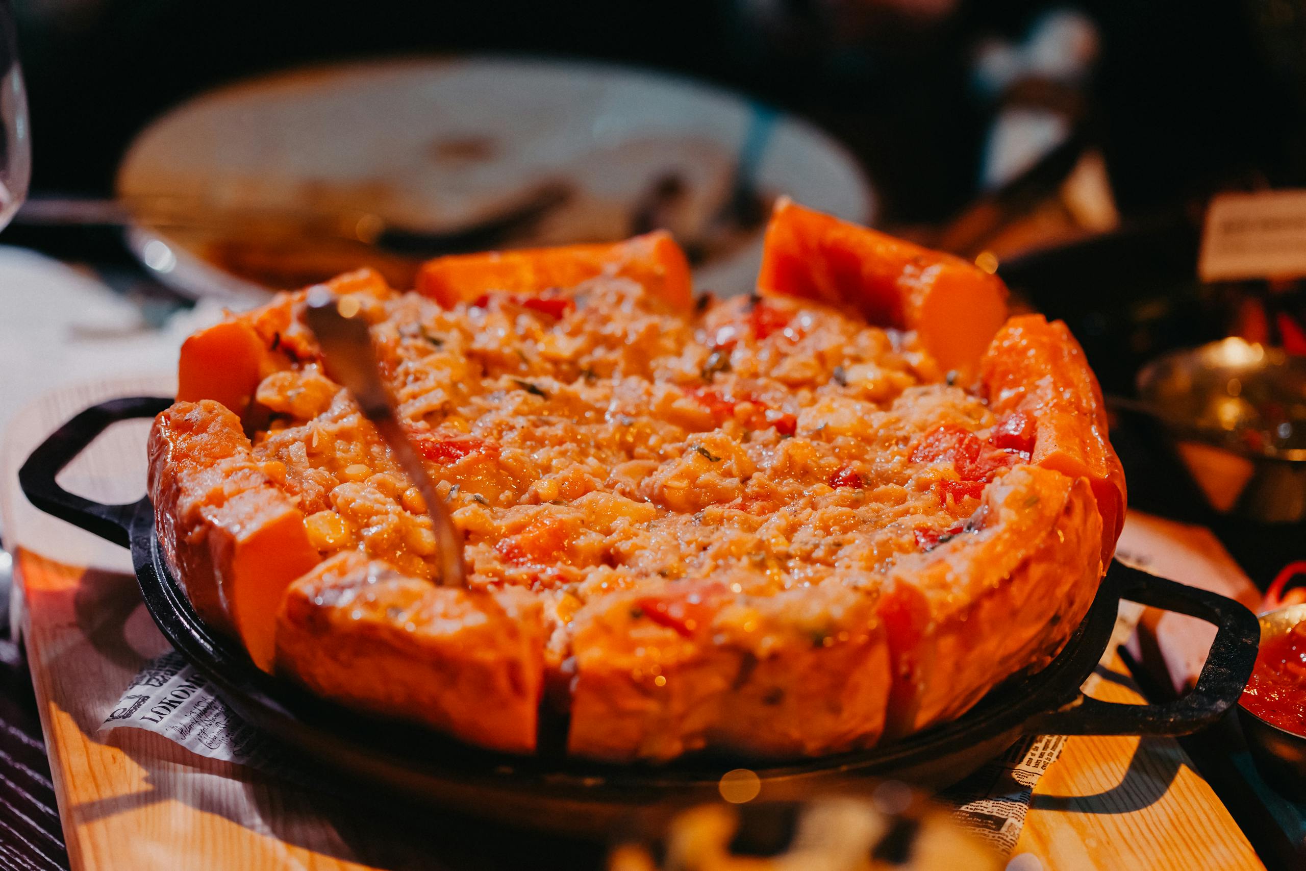 Close-up of a cheesy deep dish pizza with vegetables, perfect for a hearty meal.