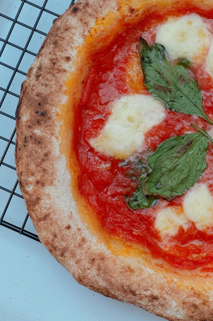 Close-up of a classic Neapolitan margarita pizza with basil and mozzarella.