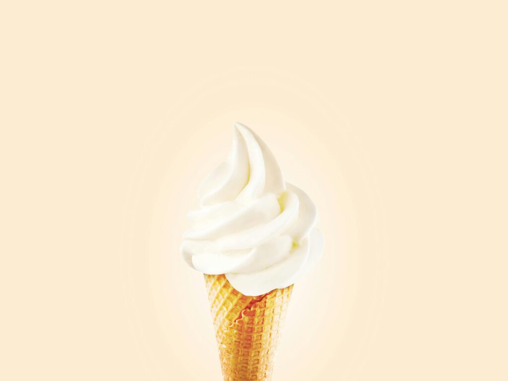 Close-up of a creamy soft serve mc flurry ice cream cone on a bright background.