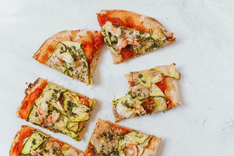 Top view of sliced Italian pinsa with zucchini and herbs, perfect for food lovers.